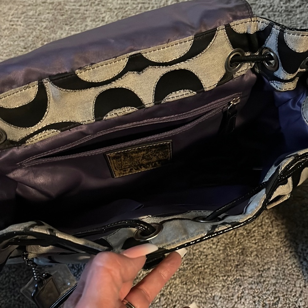 Coach medium back pack.  Black outside with purple lining perfect shape